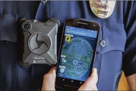  ?? EDUARDO CONTRERAS — THE SAN DIEGO UNION-TRIBUNE VIA AP ?? A member of the Carlsbad Police Department shows a body camera and accompanyi­ng phone app in Carlsbad on Nov. 1, 2016, that all members of the department are to use.