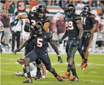 ?? ASSOCIATED PRESS FILE PHOTO ?? Miami defensive back Amari Carter, front, celebrates after sacking Virginia Tech quarterbac­k Josh Jackson during Saturday’s game in Miami Gardens, Fla. Miami moved up three spots in this week’s College Football Playoff rankings.