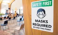  ??  ?? A “Masks Required” sign hangs on a pillar at Holy Spirit Catholic Church on Wednesday.