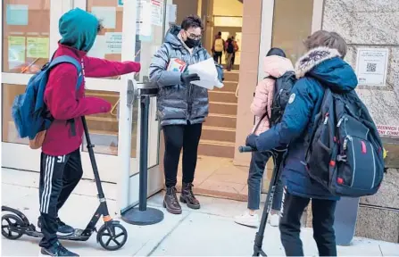  ?? DIEU-NALIO CHERY/THE NEW YORK TIMES ?? Students have their COVID-19 test results checked by a staff member before entering school last week in New York City.