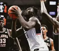  ?? Jessica Hill / Associated Press ?? UConn’s Adama Sanogo, center, looks to shoot against Oklahoma State on Dec. 1 in Storrs.