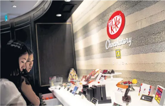  ?? PHOTOS BY ?? LEFT Customers look at different KitKat flavours at a ‘Chocolator­y’ boutique shop in Tokyo.