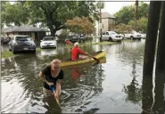  ?? NICK REIMANN/THE ADVOCATE VIA AP ?? People cope with the aftermath of severe weather in the Broadmoor neighborho­od in New Orleans, Wednesday.