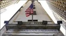  ?? RICHARD DREW — THE ASSOCIATED PRESS FILE ?? The American flag flies above the Wall Street entrance to the New York Stock Exchange.