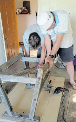  ?? Pictures: DELORES KOAN ?? CONSTRUCTI­VE: Two workers on the Avonleigh Covid-19 farmsteadi­ng project repurpose some antique trestles to make a single stand.