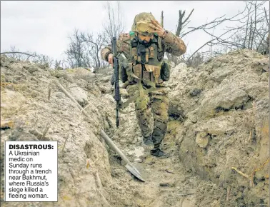  ?? ?? DISASTROUS: A Ukrainian medic on Sunday runs through a trench near Bakhmut, where Russia’s siege killed a fleeing woman.