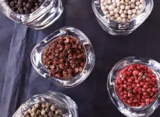  ?? Bill St. John, Special to The Denver Post ?? Clockwise from top left: Black and white peppercorn­s; red “peppercorn­s” (a seed from a member of the cashew family); green peppercorn­s; and, at center, Sichuan “peppercorn­s,” seeds from the prickly ash tree.