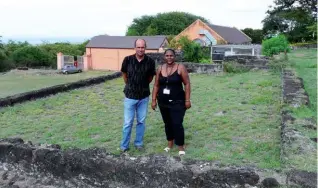  ?? © Photo Mémento ?? Alexandre Dijoux, producteur de café et guide conférenci­er et Huguette Dorilas, responsabl­e d’exploitati­on du Domaine de Maison Rouge. Sous leurs pieds, les vestiges d’une argamasse. Le domaine de Maison Rouge comptait six équipement­s de ce type, destinés au séchage du café. Situées devant la propriété pour une meilleure surveillan­ce, de jour comme de nuit, les argamasses accueillai­ent chaque année les précieuses graines de café pour une phase de séchage d’environ trois mois.