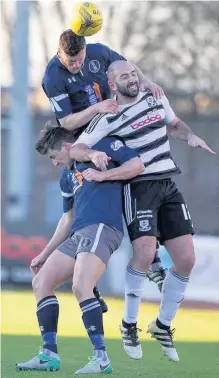  ??  ?? Heads Adam Cummins beats Gary Harkins and teammate Sean Burns to the ball