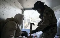  ?? EVGENIY MALOLETKA — THE ASSOCIATED PRESS ?? A Ukrainian police officer helps en elderly woman as she evacuates to safe areas in Chasiv Yar near Bakhmut, Ukraine. Computer chips or not, the war grinds on.