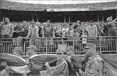  ?? [EMMA HOWELLS/DISPATCH PHOTOS] ?? Members of the Ohio Army and Ohio Air national guards carry the U.S. flag onto the field before the Ohio State-Army football game Saturday at Ohio Stadium.