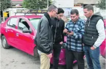  ?? Fadel Senna / AFP ?? Taxi drivers check the Uber app to waylay the app’s drivers as they wait for customers in Casablanca this week.