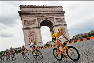  ?? CHRISTOPHE ENA/AP PHOTO ?? Britain’s Chris Froome, wearing the overall leader’s yellow jersey, passes the Arc de Triomphe on Sunday during the twenty-first and last stage of the Tour de France in Paris.