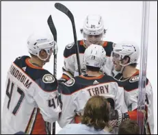  ?? Associated Press ?? Ducks right wing Troy Terry (19) is greeted by teammates after he scored a goal against the Seattle Kraken during the second period on Thursday in Seattle. Terry extended his NHL-leading scoring streak to 13 games, while the Ducks beat the Kraken 7-4 to win their sixth straight game.