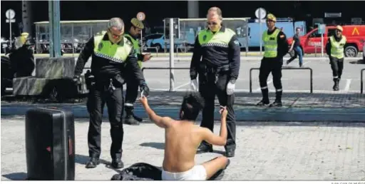  ?? JUAN CARLOS MUÑOZ ?? Policías locales de Sevilla piden la documentac­ión a un hombre en las inmediacio­nes de Santa Justa, al comienzo de la cuarentena.