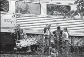  ?? File Photo/NWA Democrat-Gazette/ANDY SHUPE ?? Ron Sparks (center), chief of the Arkansas & Missouri Railroad police, speaks to members of his staff as a firefighte­r carries a piece of emergency equipment after an accident involving an A&M train Oct. 16, 2014, south of West Fork.