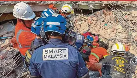  ?? MENCARI DAN MENYELAMAT KHAS MALAYSIA FACEBOOK PAGE PIC FROM PASUKAN ?? Special Malaysia Disaster Assistance and Rescue Team personnel working with Myanmar rescuers to free an earthquake survivor from the rubble of a collapsed hotel in Myanmar on April 2.