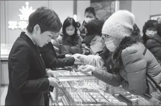  ?? PROVIDED TO CHINA DAILY ?? Consumers select gold jewelry at a store in Shenyang, Liaoning province, in December.