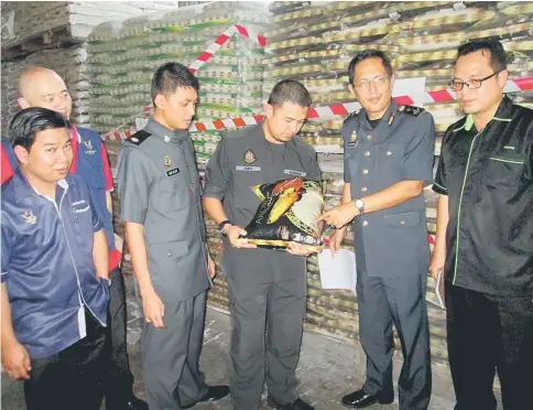  ?? Photo by Jeffery Mostapa ?? Abdul Hafidz (second right) pointing to a pack of rice with halal logo not recognised by Jais and Jakim. —