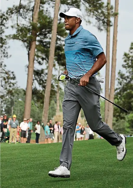  ??  ?? Tiger Woods running to the seventh tee during a practice round on Monday. — AP