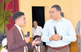  ?? ?? Prime Minister Andrew Holness (right) engages Martin Bergeron, deputy head boy at Manchester High School, during his visit to the school in Mandeville on Friday, January 12.