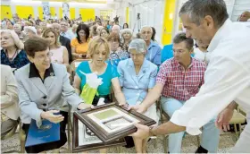  ??  ?? El presidente de la junta de los Centros Sor Isolina, Luis A. Ferré Rangel entrega un reconocimi­ento a la periodista Millie Cangiano.