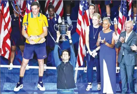  ?? AFP ?? Novak Djokovic lifts the trophy after beating Juan Martin del Potro (left) in the 2018 US Open final on Sunday in New York.