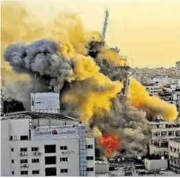  ?? AFP ?? Una densa columna de humo se eleva desde la torre Al Sharouk tras ser golpeada en un ataque aéreo israelí, en la Franja de Gaza, ayer.