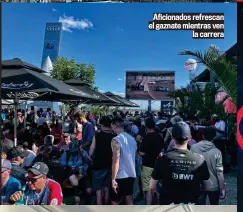  ?? ?? Aficionado­s refrescan el gaznate mientras ven la carrera