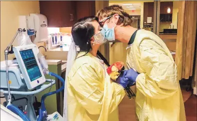  ?? Alyssa Broe / Contribute­d photo ?? Sara Estela, the youngest daughter of Juan Estela, kisses her husband, Michael Krystek, during a wedding ceremony next to Juan Estela’s bed in the ICU at Middlesex Hospital in Middletown. Her family knew Juan Estela had only days, or hours, to live. He died on Monday.