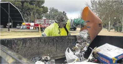  ?? CHUS MARCHADOR ?? Un operario, ayer, echando un capazo lleno de basura a uno de los contenedor­es que se instalaron.