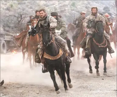  ?? Associated Press photos ?? This image released by Warner Bros. Entertainm­ent shows Chris Hemsworth, centre, in a scene from “12 Strong.”