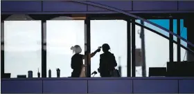  ?? (AP file/Star Tribune/Alex Kormann) ?? A health care worker takes the temperatur­e April 10 of a visitor to Essentia Health who was crossing over a skywalk bridge from the adjoining parking deck, in Duluth, Minn. A flood of new research suggests that far more people have had the novel coronaviru­s without any symptoms, fueling hope that it will turn out to be much less lethal than originally feared.