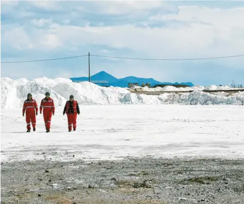 ?? Foto: Georg Ismar, dpa ?? Nein, das sind nicht die Alpen im Hintergrun­d, und die drei Menschen hier gehen auch nicht auf Schnee. Das ist der größte Salzsee der Welt im Hochland von Bolivien, und unter der Kruste schlummern gigantisch­e Lithium-Reserven.
