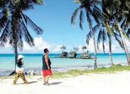  ??  ?? WALKING ON THE SAND — A couple walks along the white beach of Boracay Island, taken when the country’s most popular beach destinatio­n reopened to domestic tourists in October 2020.