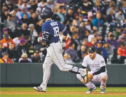  ??  ?? Rockies third baseman Nolan Arenado watches San Diego Padres catcher Austin Hedges trot past him after slugging a solo home run off Tyler Anderson during the sixth inning Tuesday night at Coors Field. That provided the go-ahead run in the Padres’ 4-3 victory.