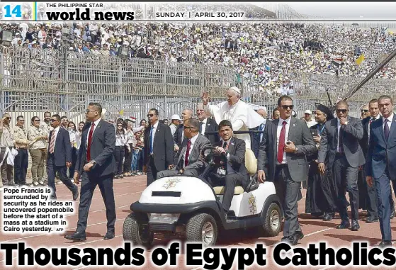  ?? AFP ?? Pope Francis is surrounded by security as he rides an uncovered popemobile before the start of a mass at a stadium in Cairo yesterday.