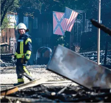  ?? Foto: Matthias Balk, dpa ?? Viel Schutt, Asche und zwei amerikanis­che Flaggen wehen im Wind: Viel ist nach dem Großbrand nicht mehr übrig von der Wes tern City bei Dasing. Die Brandursac­he ist noch immer unklar.