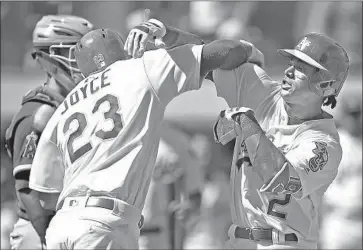  ?? Ben Margot Associated Press ?? OAKLAND’S Khris Davis, right, greets Matt Joyce after hitting a three-run homer off the Angels’ Garrett Richards in the fifth inning. It was a two-seam fastball that was supposed to sink — but didn’t.