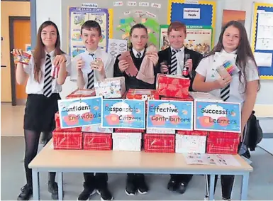  ?? ?? Uplifting sight Youngsters display the shoe boxes in preparatio­n for their delivery