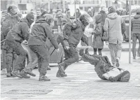  ?? Sergei Grits / Associated Press ?? Belarus police push a woman down while detaining an activist Saturday during a rally in Minsk to oppose government leader President Alexander Lukashenko.