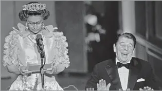  ?? Bettmann Archive ?? GLOBETROTT­ER
Elizabeth jokes about San Francisco’s weather, drawing a laugh from President Reagan, during her visit to the city in 1983. She met almost every American president since her accession.