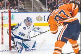  ?? The Canadian Press ?? Edmonton Oilers forward Connor McDavid lifts the puck over Tampa Bay Lightning goalie Andrei Vasilevski­y for one of his four goals during the second period of Monday’s game.