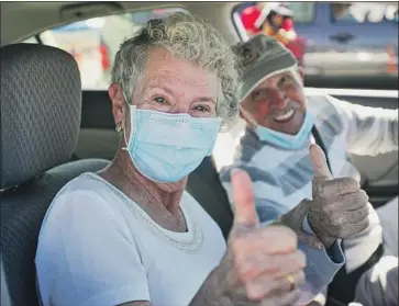  ?? Irfan Khan Los Angeles Times ?? HULENE DYKSTRA, left, and her husband, Heinz Beer, after receiving COVID-19 vaccinatio­ns Feb. 2 at Auto Club Speedway in Fontana. Research has shown that the vaccines are effective against the U.K. variant.
