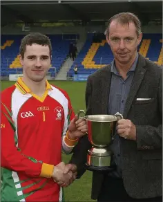  ??  ?? Kiltegan captain Luke Byrne receives the JAHC cup from Martin Fitzgerald.