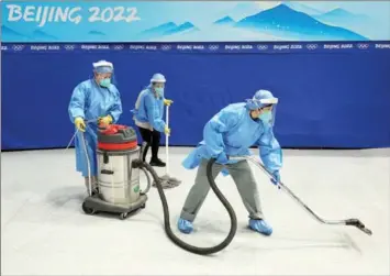  ?? HARRY HOW / GETTY IMAGES ?? Workers disinfect a stadium before the men’s ice hockey final between Finland and the Russian Olympic Committee.