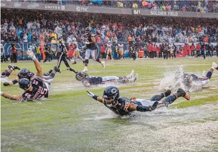  ?? BRIAN CASSELLA/CHICAGO TRIBUNE ?? Bears quarterbac­k Justin Fields and teammates splash into the end zone as they celebrate their season-opening win against the 49ers on Sept. 11 at Soldier Field.