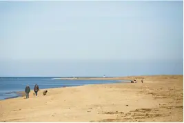  ?? STAFF FILE ?? People walk along the beach at First Landing State Park in Virginia Beach.