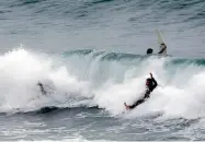  ?? — AFP ?? Surfers take to the water at Cottesloe beach, Perth after unusually large waves created by a storm on Sunday. A massive “once-in-a-decade” storm is expected to hit Australia’s west coast on Sunday and Monday.