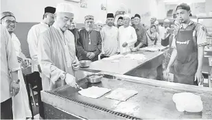  ?? — Gambar Bernama ?? TUNJUK BAKAT: Sultan Abdullah menunjukka­n bakat memasak roti canai ketika bersarapan bersama rakyat di sebuah restoran selepas menunaikan solat Subuh di Masjid Ash Shafie, Kotasas, dekat Kuantan, semalam.